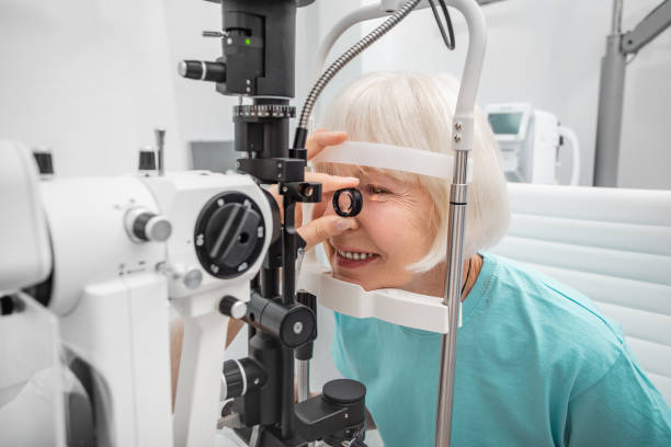 Elderly woman eyesight test with binocular slit-lamp. Checking retina of a female eye close-up. Ophthalmology Clinic Elderly woman eyesight test with binocular slit-lamp. Checking retina of a female eye close-up. Ophthalmology Clinic glaucoma photos stock pictures, royalty-free photos & images