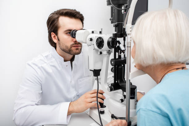 istock Optometrist checking vision to an old patient using a slit lamp. Eye exam patient with cataract 1272441532