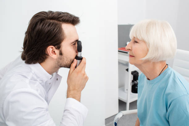 istock Optometrist doing eye exam to a patient using an ophthalmoscope, cataract diagnostic. Vision check-up, close-up 1272441546