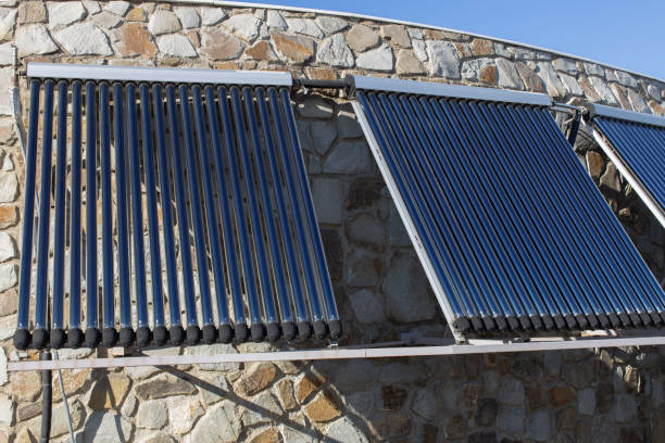 solar-wasser-heizung auf wand oder dach des hauses installiert. 3 platten aus glas koaxialen rohren mit wasser, um wärme anzusammeln. seitenansicht. konzept umweltfreundliche und wirtschaftliche hausheizung - water pipe boiler pipe control panel stock-fotos und bilder