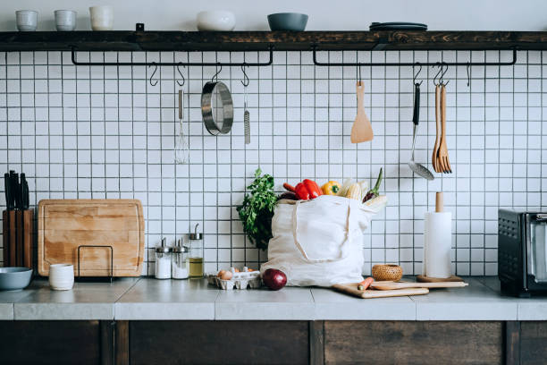 una borsa riutilizzabile piena di verdure biologiche colorate e fresche e generi alimentari sul bancone della cucina. zero sprechi shopping e concetto di stile di vita sostenibile - supermarket groceries shopping healthy lifestyle foto e immagini stock