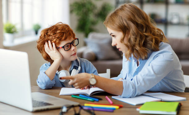 istock Mother helping child with online lesson at home 1272447192