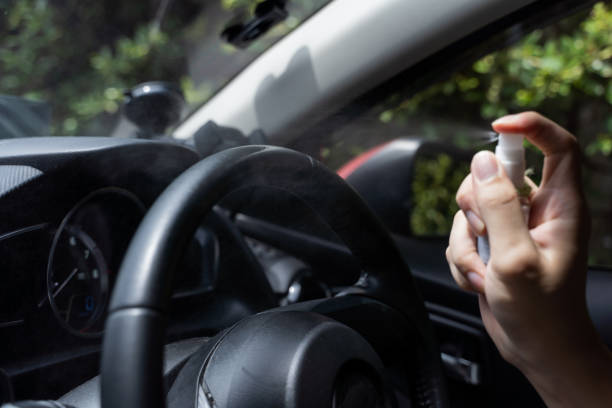 istock Human hand using alcohol spray to disinfect steering wheel in the car. Spraying prevent infection of coronavirus Covid-19 1272448557