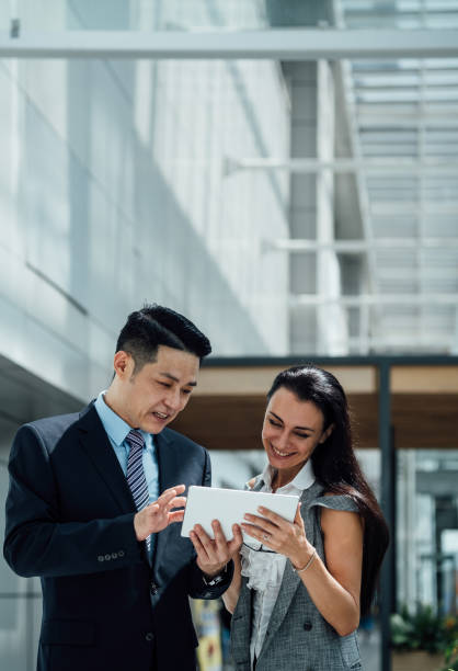 istock Two confident business people using a digital tablet together stock photo 1272448655
