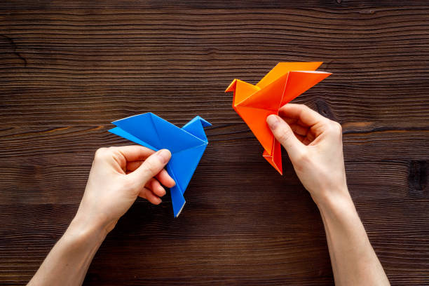 istock DIY concept. Doing origami paper bird, Top view 1272448736