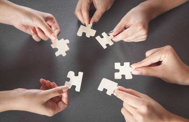 istock Hands of people holding jigsaw puzzle. Partnership, Success, Teamwork 1272449873