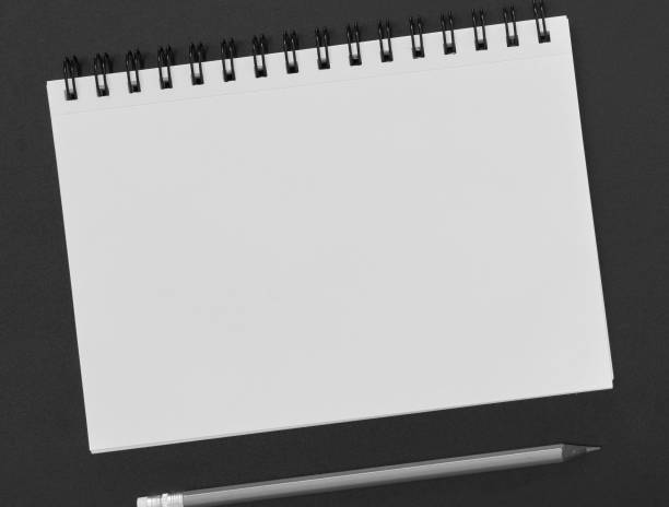 istock Blank paper notepad and pencil on blackboard 1272449981