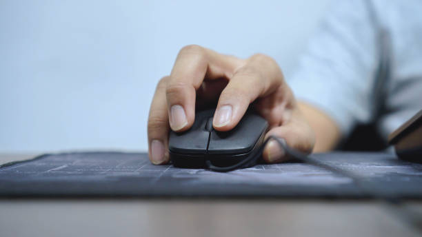 istock close up young man hand using mouse to clicking and check job at desktop table in home office for working concept 1272453299