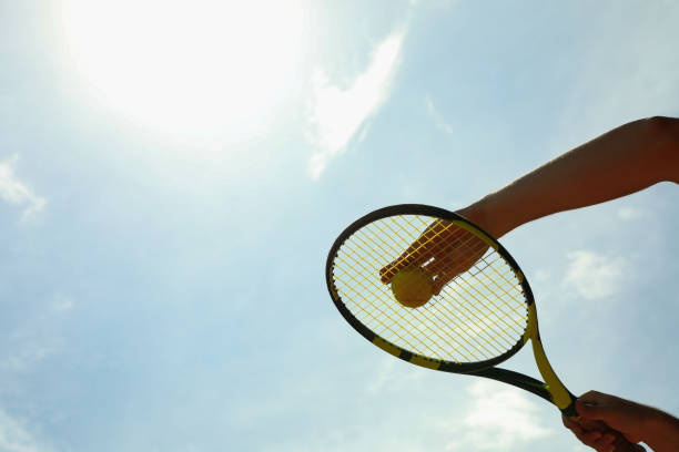 istock Person hold racket and ball against sky, space for text 1272453307