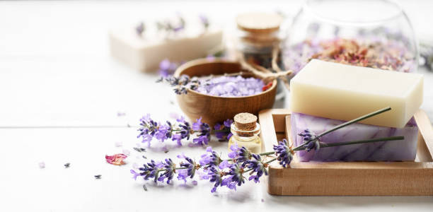 lavendel seife und spa-produkte mit lavendelblüten auf einem weißen tisch. - badesalz stock-fotos und bilder