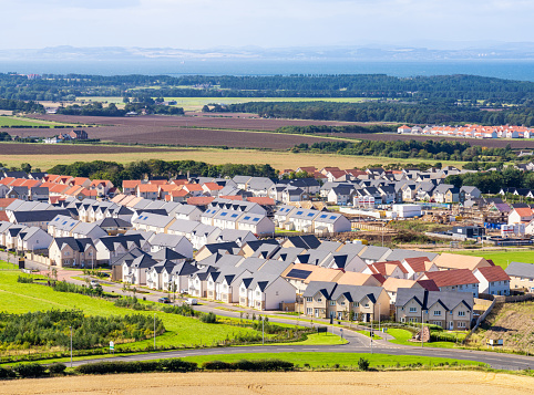 New homes in a building development surrounded by agricultural fields in East Lothian, Scotland.