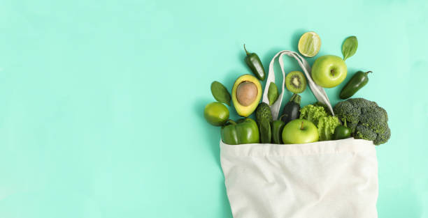istock Bag with vegetables and fruits on mint background 1272455997