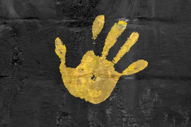 Photo of yellow palm mark on black wall