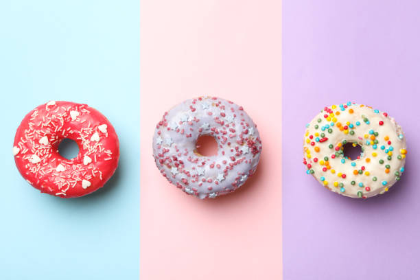 istock Tasty donuts on three tone background, top view 1272456209