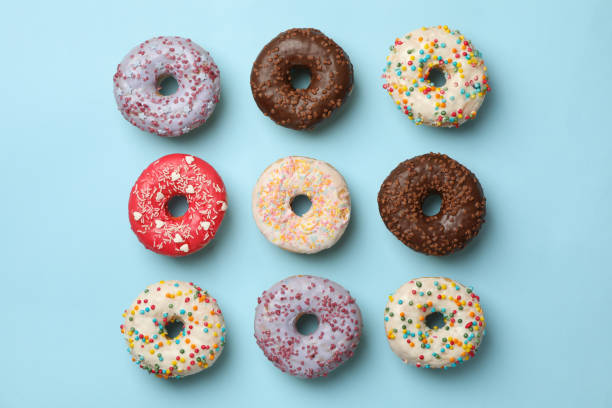 istock Flat lay with tasty donuts on blue background 1272456380