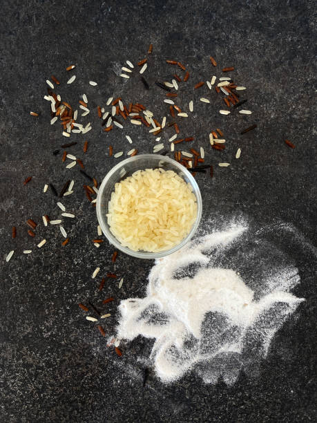 farine de riz et de riz brun, blanc, brun, sauvage dans un bateau de sauce sur une surface de pierre texturée noire. vue d’en haut - rice black wild rice dry photos et images de collection
