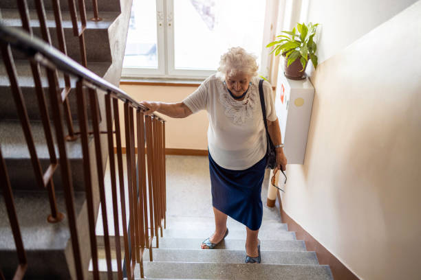 mujer mayor trepando escalera con dificultad - old senior adult women tired fotografías e imágenes de stock