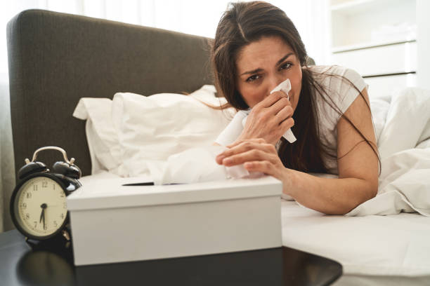 istock Sick lady blowing her nose in bed 1272458593