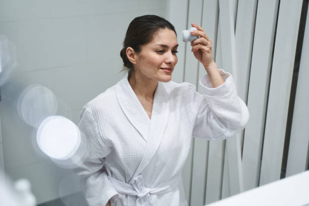 istock Focused lady using a facial cleansing brush 1272458685
