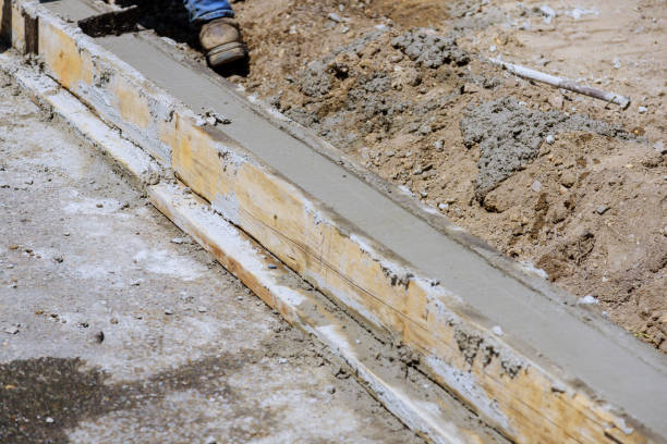 un marciapiede è in costruzione, un cordolo di cemento è in fase di installazione le fondamenta della strada preparata. - formwork concrete curb cement foto e immagini stock