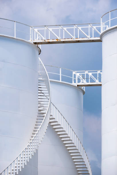 istock Low angle view of curve spiral staircase on white storage fuel tanks in vertical frame 1272460356