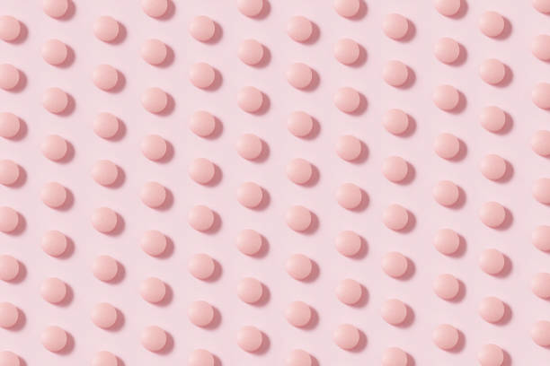 kreis geformte pillen auf rosa hintergrund - pink pill stock-fotos und bilder