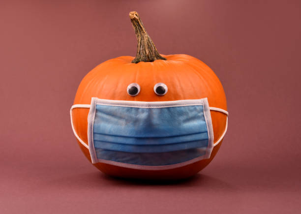 istock Orange pumpkin with protective mask stock images 1272462391