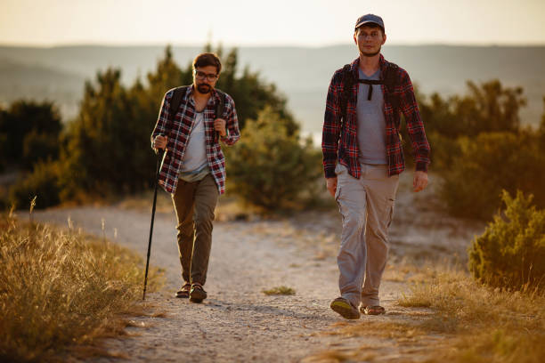 istock two men hikers enjoy a walk in nature, sunset time in summer 1272462394