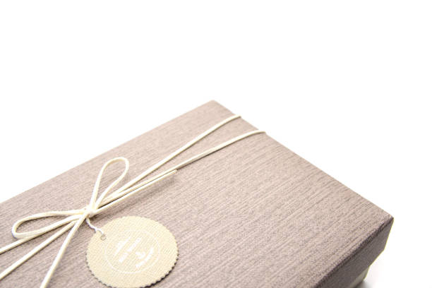 istock A gift box isolated over white background with copy space. Box is tied with a cord with a label with Wishes and Happiness. Holiday, birthday, New Year and Christmas gift concept. 1272462433