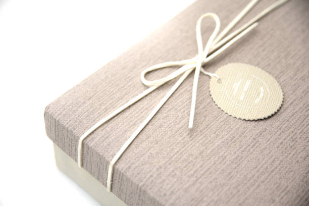 istock A gift box isolated over white background with copy space. Box is tied with a cord with a label with Wishes and Happiness. Holiday, birthday, New Year and Christmas gift concept. 1272462454