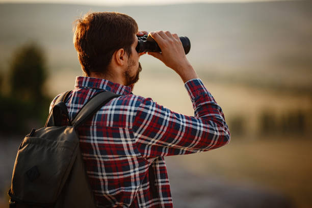 istock Guy looking at binoculars in hill. man in t-shirt with backpack 1272462547