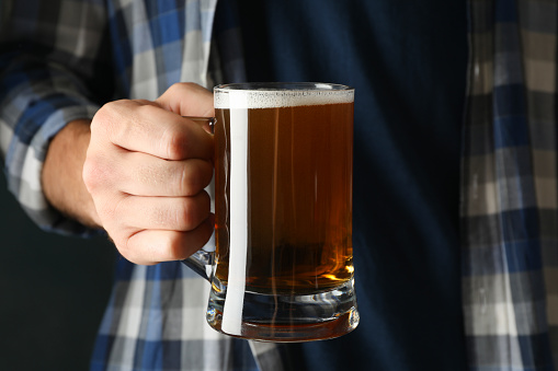Man in checkered shirt hold glass of beer