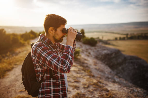 istock Guy looking at binoculars in hill. man in t-shirt with backpack 1272462853