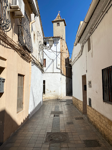 Valencia, Spain - September 11, 2020: Narrow street with shiny tiled floor in the Benimaclet district. This old area was an independent town until the growth of the city caused its integration to it