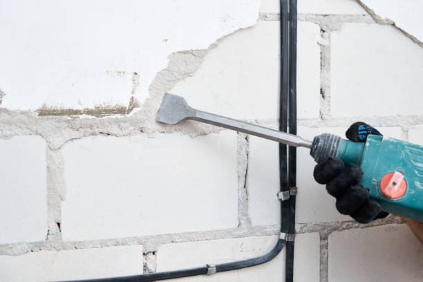 istock Man with demolition hammer remove stucco from wall. Renovation concept 1272466830