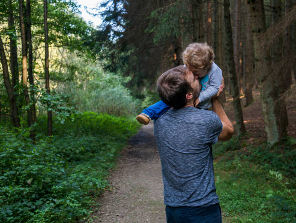 istock Father and son playing and cuddling in forest environment 1272468416