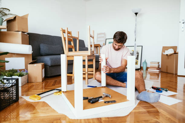 istock Young man assembling furniture at home 1272469279