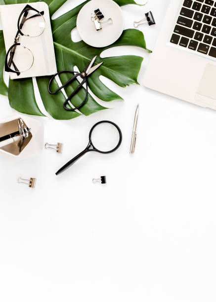 istock Home office workspace mockup with laptop, tropical leaves Monstera, clipboard, notebook and accessories on white background. Flat lay, top view 1272471084