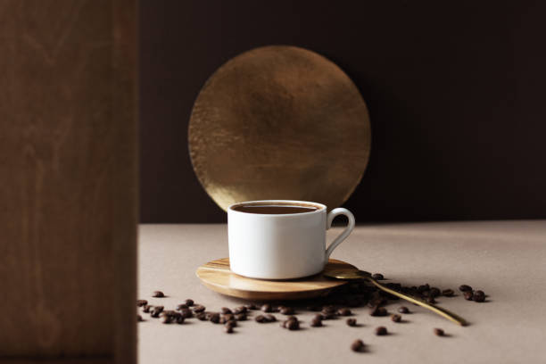 A cup of coffee and coffee beans on table in modern brown interior.