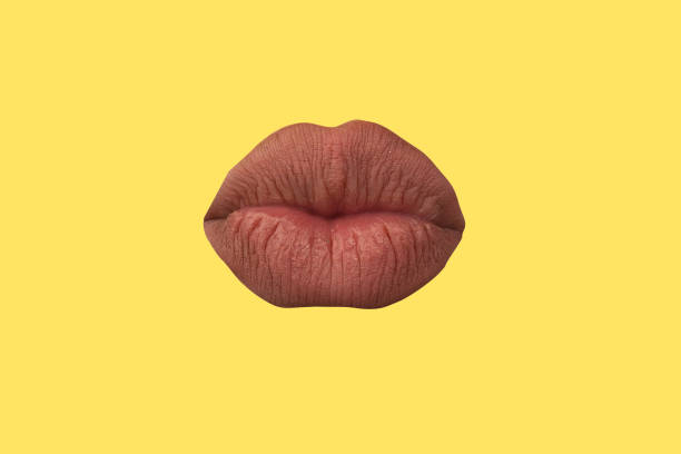 istock Woman's lips close up isolated on yellow background 1272471308