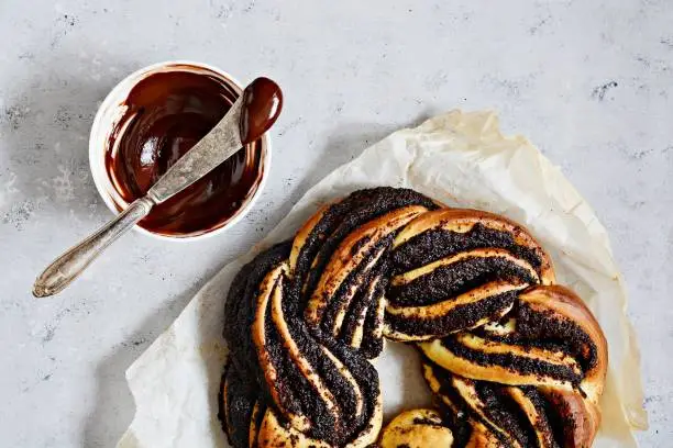 Photo of Estonian Kringle. Brioche with poppy and chocolate. Wreath. Baking, national pastries. Babka.