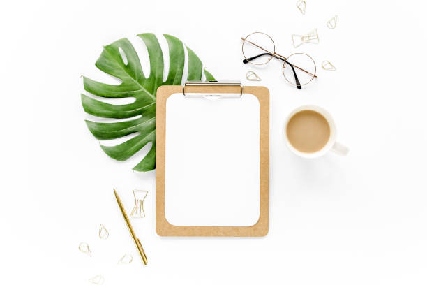istock Home office workspace mockup with tropical leaves Monstera, clipboard, and accessories on white background. Flat lay, top view 1272472626