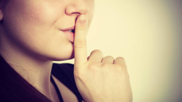 istock Woman showing silence gesture with finger 1272473074