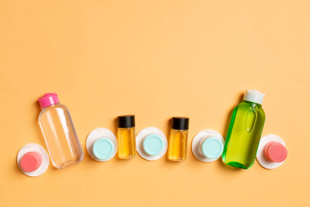 istock Group of small bottles for travelling on colored background. Copy space for your ideas. Flat lay composition of cosmetic products. Top view of cream containers with cotton pads 1272473213