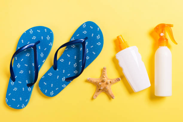 istock Sunscreen bottle or body spray on yellow background top view flat lay with copy space. Holiday vacation travel concept with beach sea accessories 1272473228
