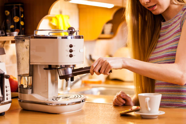 istock Woman in kitchen making coffee from machine 1272475476
