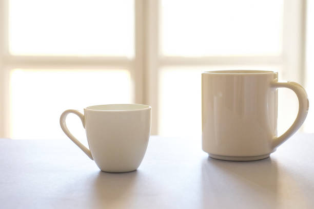 istock Two white cups of coffee on kitchen defocused background 1272475506