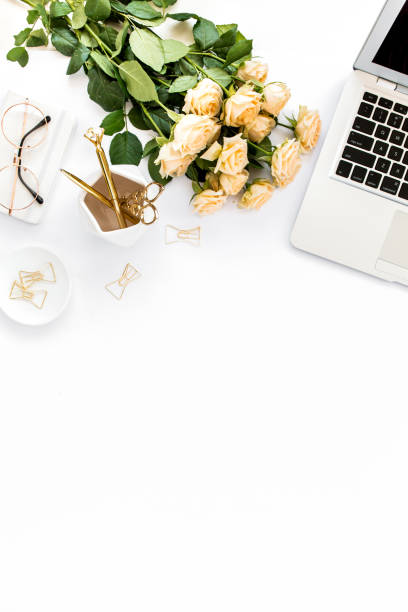 istock Female workspace with laptop, roses flowers, golden accessories, diary, computer, glasses on white background. Flat lay women's office desk. Top view 1272475571