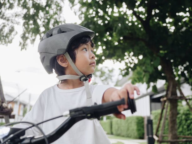 istock Kid preparing riding a bike with helmet 1272475860