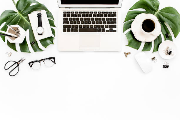 istock Home office workspace mockup with laptop, tropical leaves Monstera, clipboard, notebook and accessories on white background. Flat lay, top view 1272476139